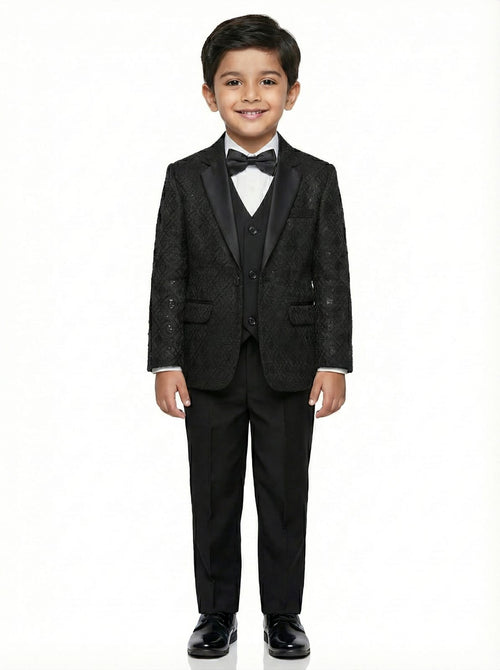 Young boy wearing a black tuxedo with a bow tie on a white background