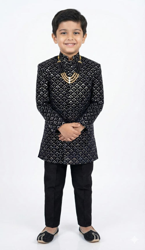 Child wearing a black embroidered sherwani on a white background