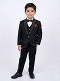 Young boy in a formal black suit with a red flower on a white background