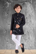 Child wearing a black and white outfit against a textured gray wall.