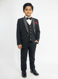 Young boy in a formal black suit with a white shirt and bow tie on a white background