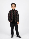 Young boy wearing a patterned jacket and black pants on a white background
