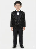 Young boy wearing a black patterned suit with a white shirt and bow tie on a white background