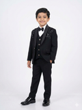 Young boy in a formal black suit with a white shirt and bow tie on a white background