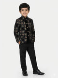 Child wearing a black patterned jacket and black pants on a white background