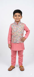 Child wearing a pink traditional outfit with a floral vest on a white background