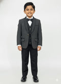 Young boy wearing a gray suit with a bow tie on a white background