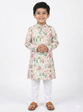 Young boy wearing a floral kurta with white pants on a white background