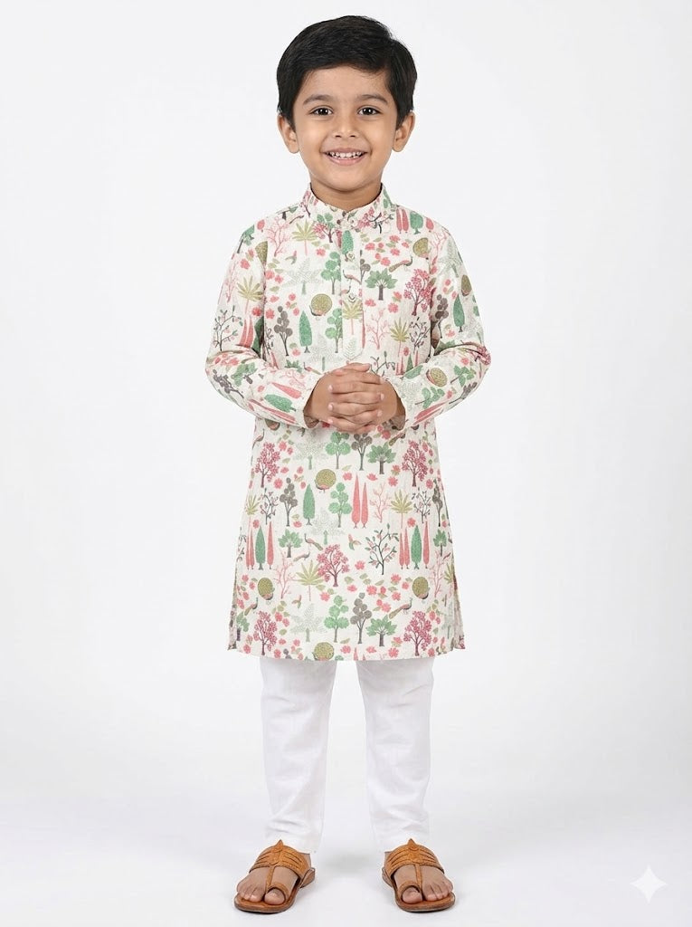 Young boy wearing a floral kurta with white pants on a white background