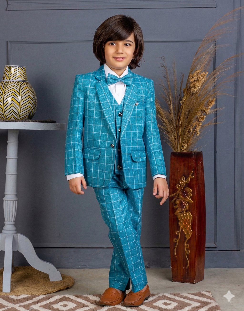 Child wearing a blue checkered suit standing in a room with decorative elements.