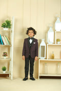 Young boy in a formal outfit standing in a room with shelves and decor.