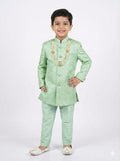 Child wearing a light green traditional outfit with gold accents on a white background