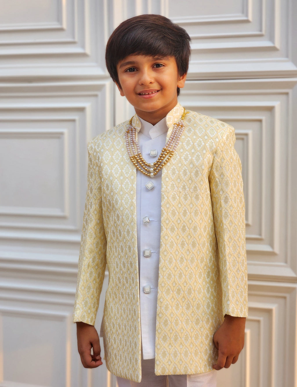 Young boy in a traditional embroidered outfit with a white background