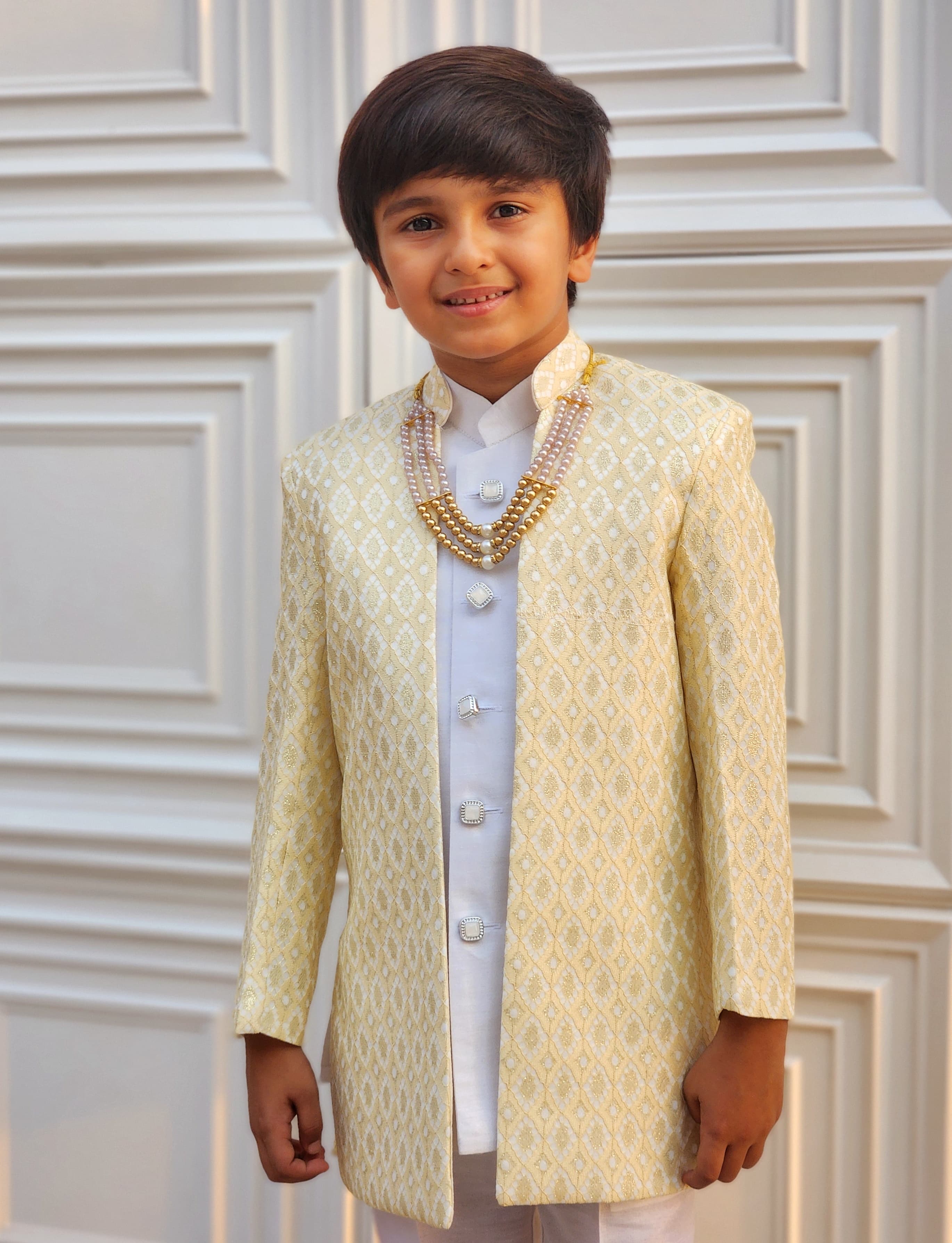 Young boy in a traditional embroidered outfit with a white background