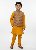 Young boy wearing a mustard yellow kurta with a patterned vest on a white background