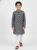 Young boy wearing a patterned kurta with white pants on a white background