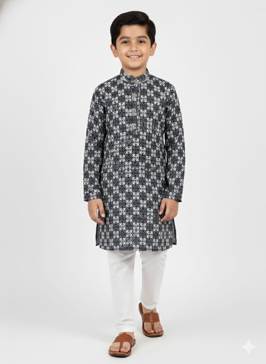 Young boy wearing a patterned kurta with white pants on a white background