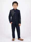Child wearing a navy blue suit with floral embroidery on a white background