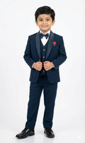Young boy in a formal navy suit with a bow tie on a white background