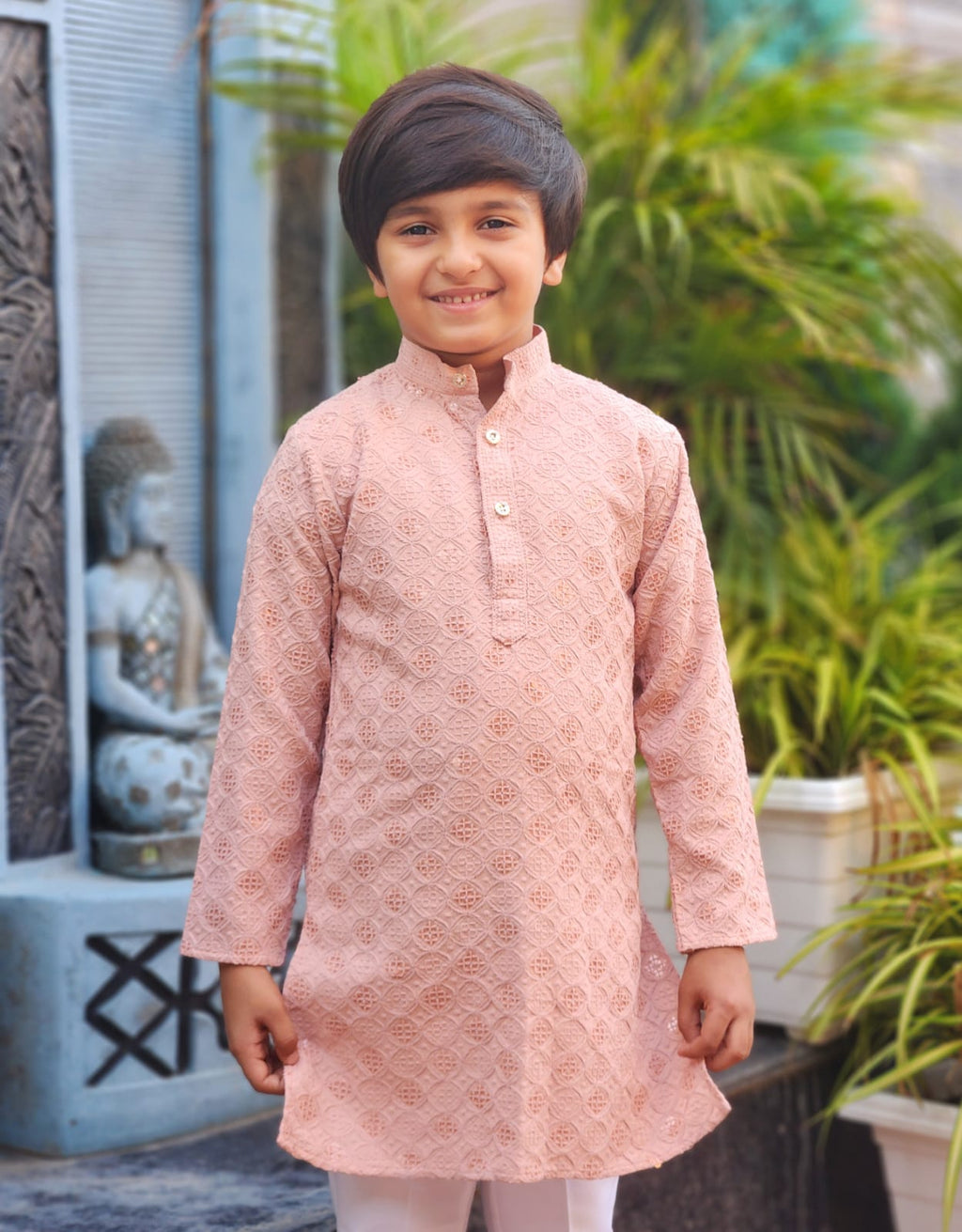 Child wearing a pink kurta with a blurred background