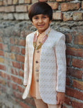 Child wearing a traditional outfit against a brick wall