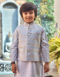 Child wearing a traditional outfit with a patterned vest in an outdoor setting