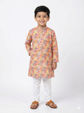 Child wearing a colorful kurta with white pants on a white background