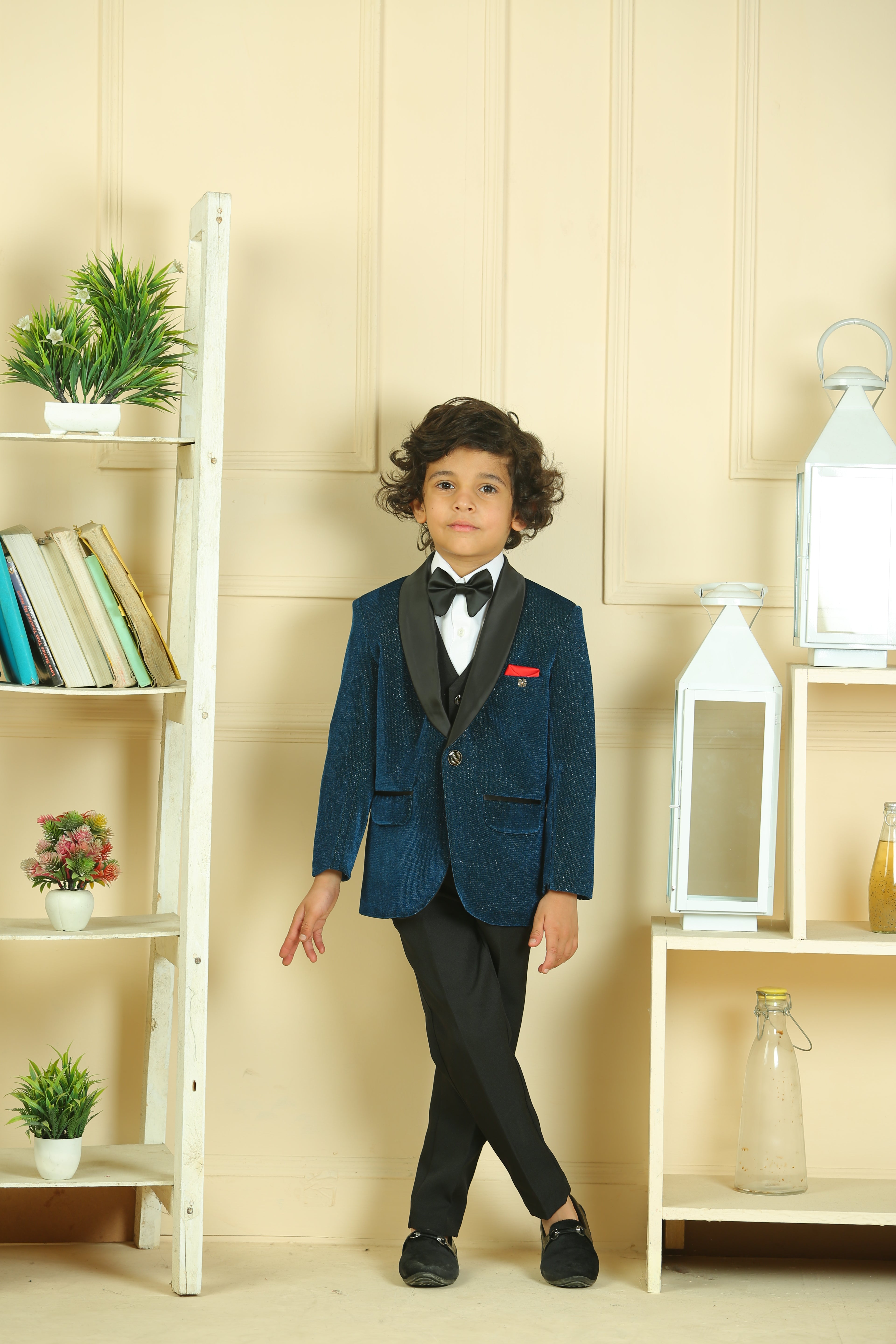 Child in a formal outfit standing in a room with shelves and decor