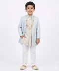 Child wearing a traditional outfit with a light blue jacket and white pants on a white background
