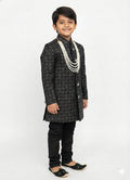 Child wearing a black and white traditional outfit on a white background
