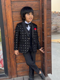 Child in a formal outfit standing against a wooden door.