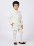 Child wearing a white embroidered sherwani on a white background