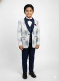 Young boy wearing a formal outfit with a jacket, vest, and pants on a white background