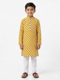 Young boy wearing a yellow kurta with white pants on a white background